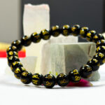 Person meditating while wearing the authentic Ohm Money Padmane spiritual guidance bracelet on their wrist.